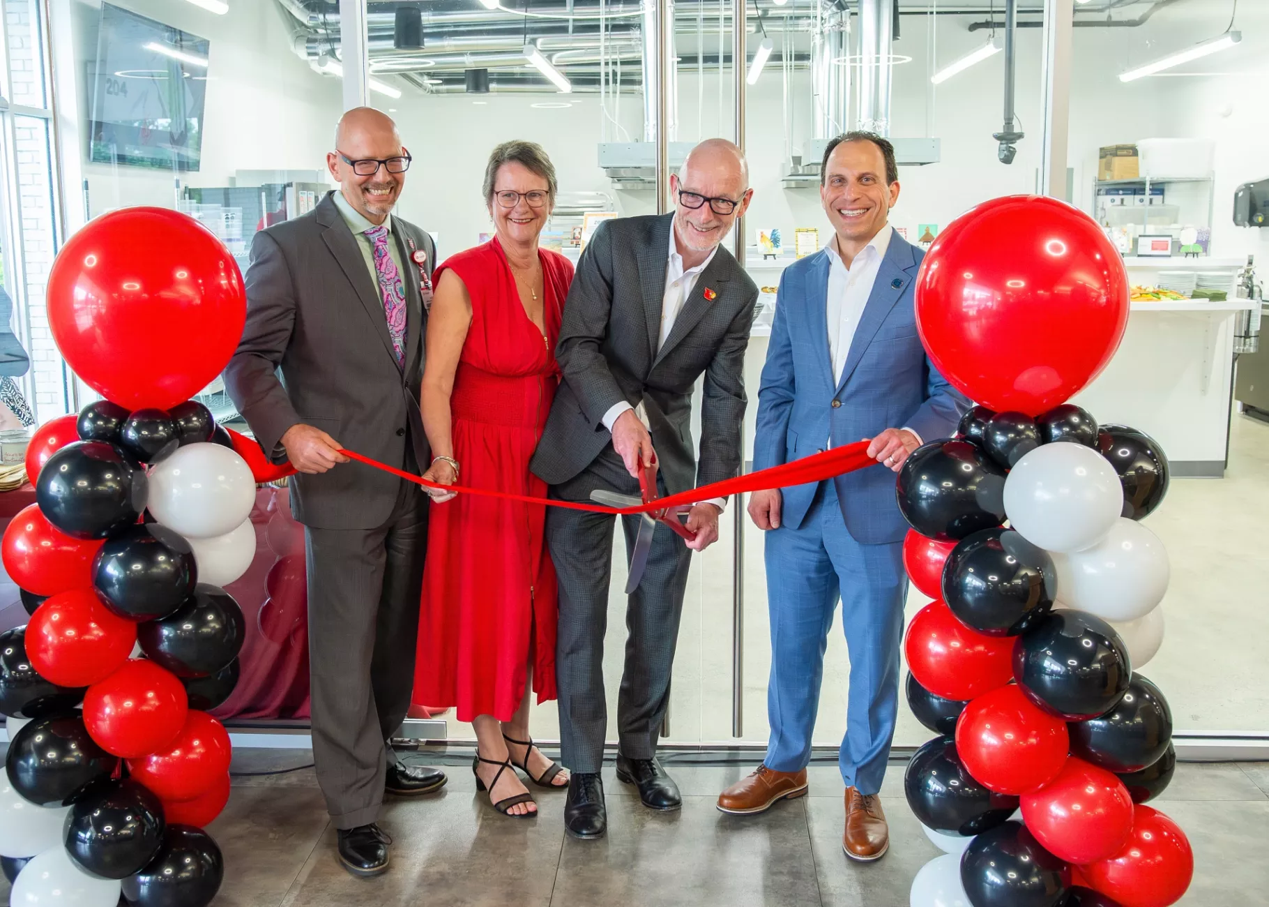 Wade Mitzel, Anna Faul, Gerry Bradley, and Mayor Craig Greenberg cutting the ribbon at the Trager Institute Culinary Medicine Kitchen opening