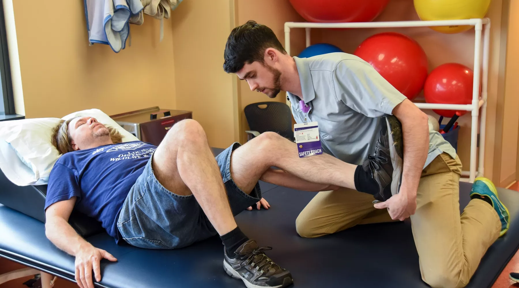 Doctor helps patient with movement in his legs