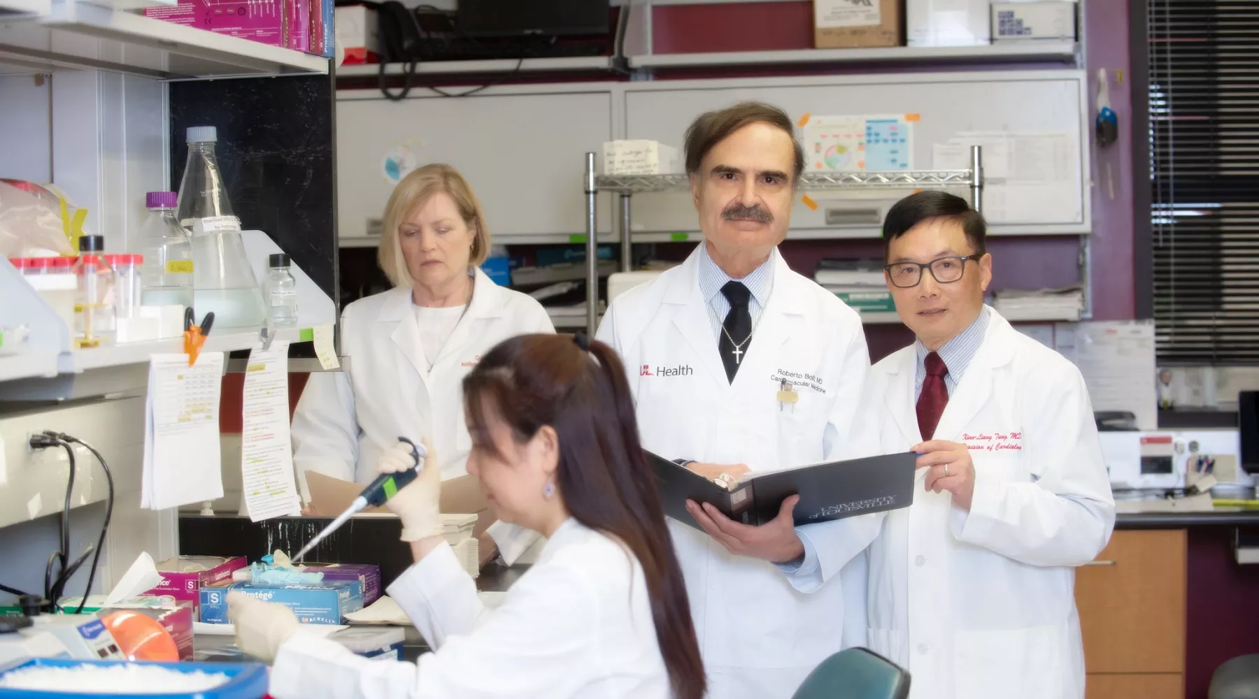 UofL cardiologist Roberto Bolli, center, with team members working in a biomedical laboratory.