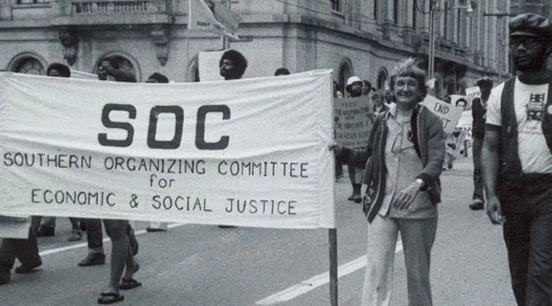 Group marching with a banner in hand that reads SOC: Southern Organizing Committee for Economic & Social Justice