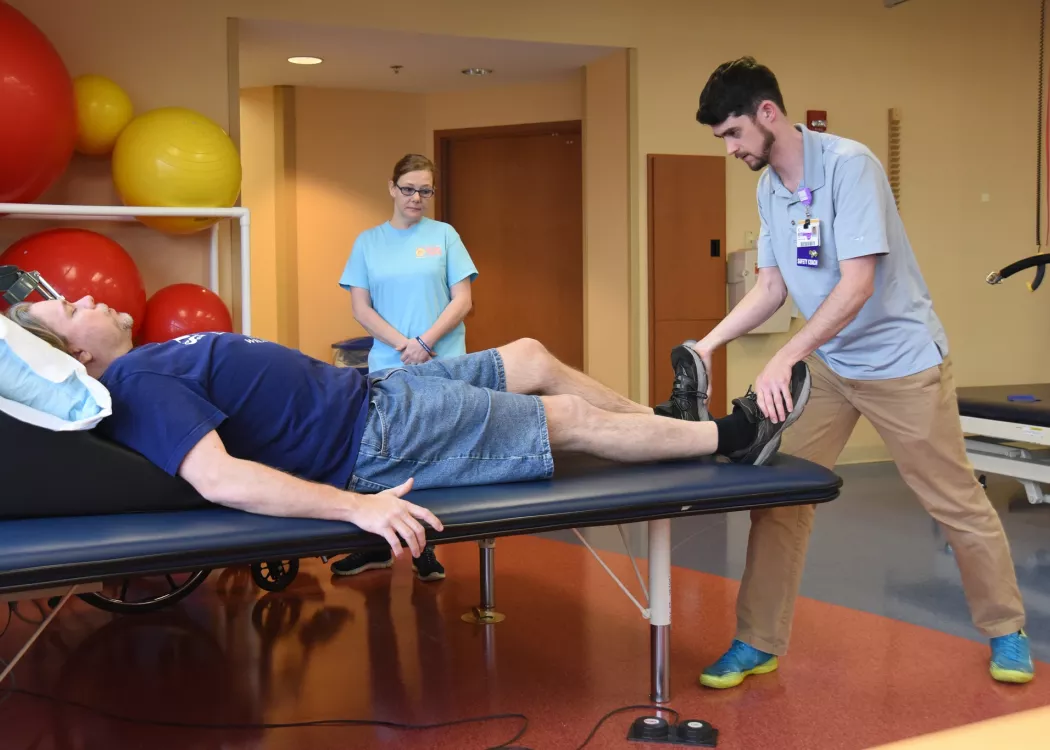 Doctor helps patient with movement in his legs