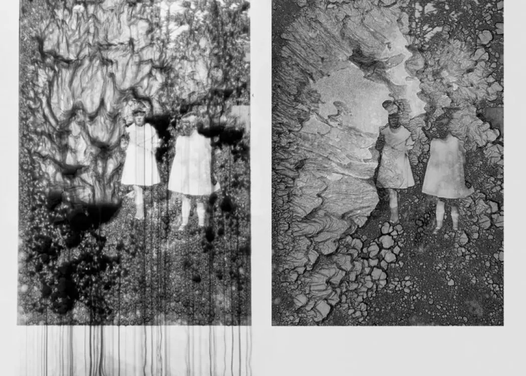 Two vertical panels showing black and white stills of two human figures in shapeless dresses on organic formations.