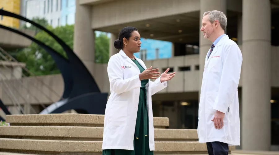 Female and male doctor having a conversation on HSC campus.