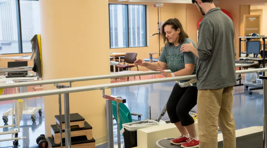 Doctor helps patient in her physical therapy session